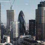 London View - Various shaped modern skyscrapers with glass mirrored facades located in financial district of London against blue sky on sunny day