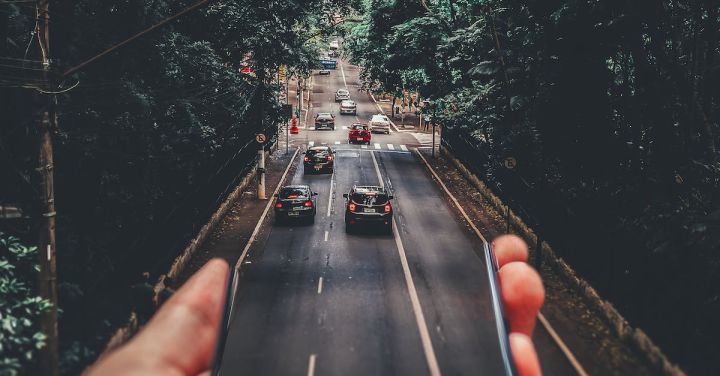 Mobility - Forced Perspective Photography of Cars Running on Road Below Smartphone